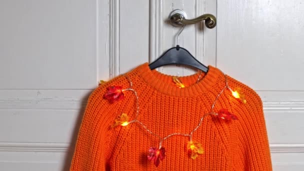 One Orange Knitted Sweater Burning Garland Autumn Leaves Hangs Black — Stock Video