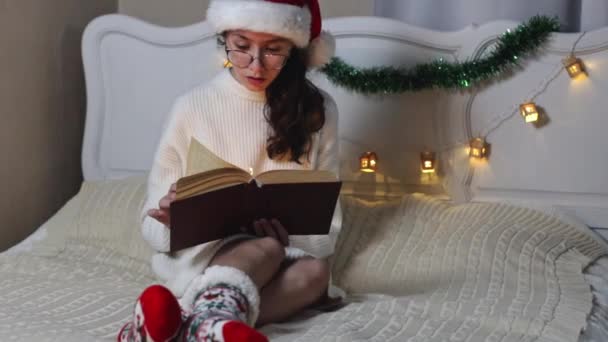 Belle Adolescente Caucasienne Lunettes Santa Claus Chapeau Lit Livre Avec — Video
