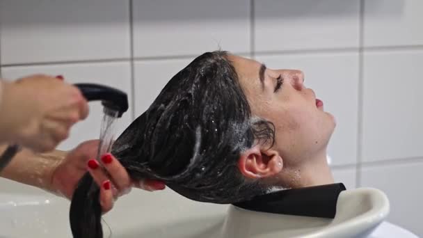 Wanita Muda Kaukasia Penata Rambut Membilas Dari Shampoo Rambut Panjang — Stok Video