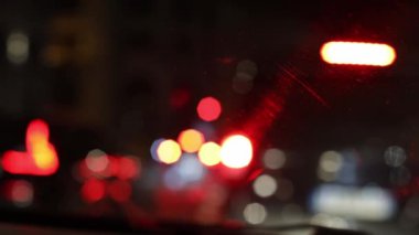 Renkli Bokeh farlarının ön camından çıkan güzel bulanık gece görüşü. Önden geçen arabaların farları, yakın çekimde. Gece hayatı konsepti.