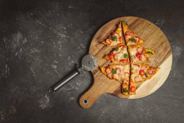 Noel ağacı pizzasını kesme tahtasıyla kes sağ arka planda bir kılıç kınıyla sol tarafta fotokopi alanı, en üstte yakın plan..