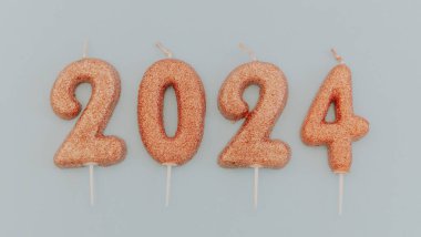 2024 numaralı parlak açık kahverengi mumlar. Ortadaki mavi arka planda yatar. Yakın plan düz olur..