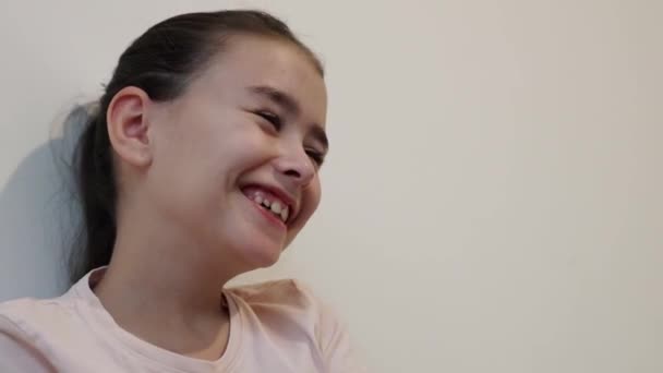 Ένα Μικρό Όμορφο Χαρούμενο Μελαχρινό Καυκάσιο Κορίτσι Κάθεται Στο Κρεβάτι — Αρχείο Βίντεο