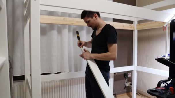 One Young Caucasian Brunette Man Hammers Wooden Nail Board Bunk — Stock Video