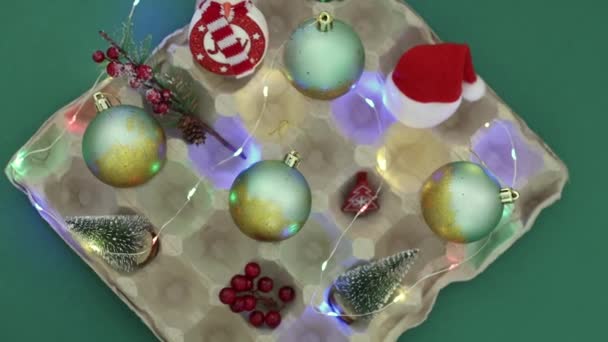 Een Kartonnen Eierschaal Met Vergulde Kerstballen Mini Kerstbomen Sneeuwpop Kerstdecor — Stockvideo