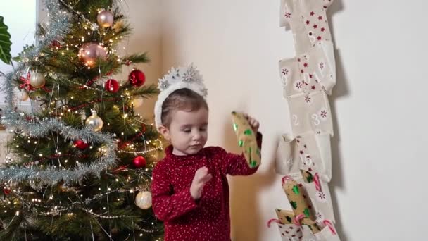 Egy Gyönyörű Kétéves Kaukázusi Lány Hópehely Fejpánttal Fején Elővesz Egy — Stock videók