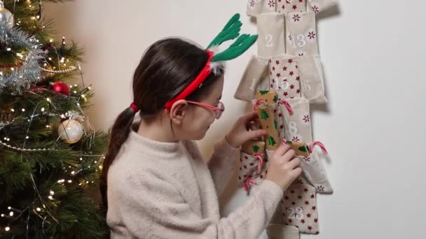 Egy Gyönyörű Kaukázusi Lány Zöld Szarvasagancsos Fejpánttal Kíváncsisággal Elővesz Egy — Stock videók