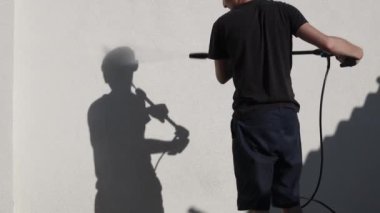 Genç, yakışıklı, esmer, beyaz tenli bir adam, bir yaz akşamı, evinin arka bahçesinde duran bir Karcher makinesini kullanarak, güçlü su basıncıyla bir duvarı yıkıyor..