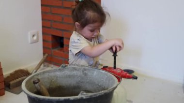 Beyaz tenli güzel bir kız gün boyunca odada yerde oturur ve bir el spreyiyle oynar. Kova içinde çimento havanını ıslatmak için su basıncına neden olur.