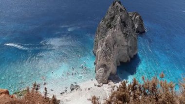Güneşli bir yaz gününde, kayalık kıyılar yakınlarındaki mavi İyon Denizi 'nde, yukarıdan yakından çekilmiş kuşbakışı manzaralı büyük bir dağın güzel panoramik manzarası. Yavaş çekim ile