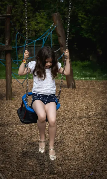 Yüzünde korku duygusu olan güzel bir Kafkas esmer kızın portresi bir yaz günü parkta salıncaktan iniyor..