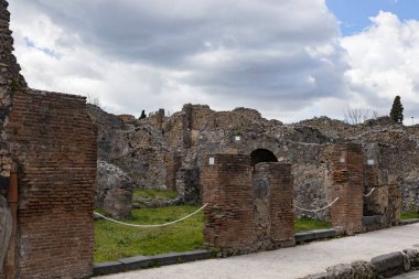 İtalya 'da bulutlu ve bulutlu bir yaz gününde, Pompeii antik kentinde ana cadde boyunca uzanan bir sıra boyunca uzanan harabelerin güzel manzarası..