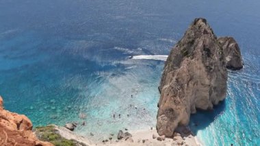 Güzel bir panoramik dağ manzarası mavi İyon Denizi 'nde kayalık kıyıya yakın bir tepesi kuşbakışı ve güneşli bir yaz gününde yanından geçen bir motorlu tekne.
