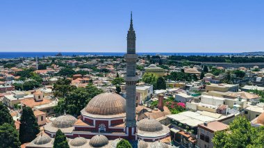 Yunanistan 'ın eski Rodos kentindeki Muhteşem Süleyman Camii' nin güzel kubbesi ve minaresi. Güneşli bir yaz gününde ufukta Ege Denizi görünüyor. Şey...
