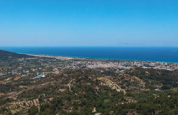 stock image Beautiful panoramic view of a modern settlement near the coastline of the Aegean Sea in a mountainous area in Greece on the island of Rhodes on a summer sunny day, side view from Mount Filerimos close up.