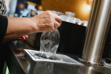 Yaşlı, tanınmayan beyaz bir kadının elleri, Prag şehrindeki samimi bir akşam kafeteryasında bira içmek için bardağı duruluyor. Yaşlılar yaşam tarzı konsepti