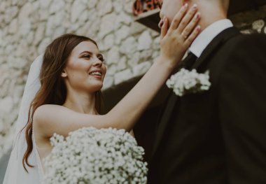 Mutlu bir gelinin güzel bir portresi. Damada şefkatle ve sevgiyle bakar. Bir yaz günü yüzünü avucuyla tutar.