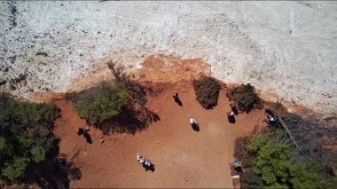 Yunanistan 'ın Zakynthos adasındaki güneşli bir yaz gününde kayalık bir ovada yürüyen tanınmayan insanlarla dolu kumlu bir uçurumdan güzel bir panoramik manzara..
