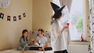 Üç beyaz güzel kız yataktaki sehpada oturup şeker yiyor ve kırmızı bir içki içiyor. Güneşli bir sonbahar sabahında yatak odasında Cadılar Bayramı 'nı birlikte kutluyorlar.