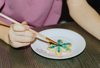 Tanımlanamayan beyaz bir kız bir masada oturuyor ve koyu gri bir masada otururken fırçayla fırçayla fırçayla fırça süslüyor. Adım adım talimatlar. 26. Adım