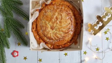 Bir kutu içinde yeni pişmiş kraliyet bisküvisi ve beyaz ahşap bir masa üzerinde altın bir taç Noel süslemeleri, yakınlaştırmalı düz bir yakın çekim.