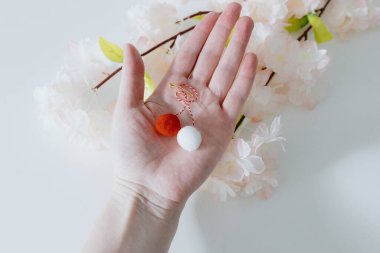 Beyaz, küçük, kırmızı, el yapımı, yumuşacık, ince bir iplik üzerinde küçük, beyaz, beyaz bir kadının avucunda uzanan, geniş bir saha derinliğine sahip, el yapımı, el yapımı, yumuşak toplar. Romen kültürü kavramı