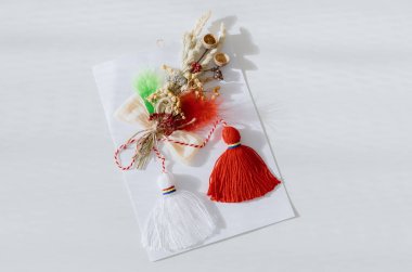 Bir adet kırmızı ve beyaz el yapımı martisör bir kağıt parçasına yapıştırılır ve beyaz bir masanın ortasında, alan derinliği ile yakın plan çekimde yatar. Romen kültürü ve gelenekleri kavramı