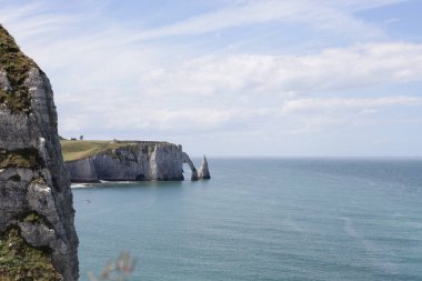 Etretat, Normandiya 'da güneşli bir yaz gününde kuzey denizinde fil hortumu şeklindeki ünlü doğal kemerin güzel manzarası. Güzel doğayı kavra