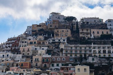 Güneşli bir yaz gününde, İtalya 'nın Positano kentinde bulutlu bir gökyüzüne karşı dağın tepesindeki yerleşim yerlerinin güzel manzarası. Güzel arka plan ve duvar kağıtlarını kavra.
