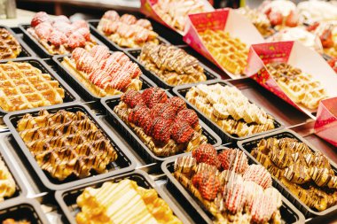 Güzel bir Belçika Waffle 'ı manzarası. Çikolata ve meyve dolgulu. Gece şehrinin açık vitrininde. Belçika hamur işleri, sokak yemekleri, seyahat zamanı.