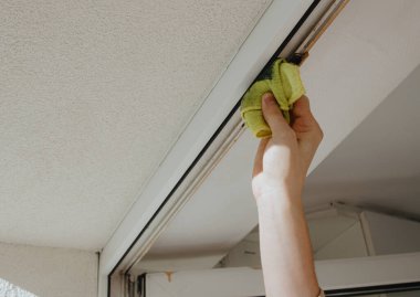 Lastik profili yapıştırmadan önce kirli plastik kapı çerçevelerini üstte yıkayan, tek elle tanınamayan beyaz bir adamın portresi, çok yakından görünüyor. Konsept