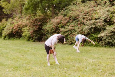 Güzel, beyaz bir kadının akıllı telefonuyla fotoğraf çekerken çekilmiş bir portresi. Bir bahar günü parkta takla atan bir kız resmi. Modern yaşam biçimi blogcularını kavra.