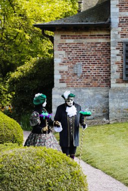 Dilbeek, Grand Bigard Şatosu, Belçika - 27 Nisan 2025: Floralia Brüksel festivalinin son haftasonu boyunca parkta el ele yürüyen Venedik kostümlü ve maskeli bir çiftin yakın görüntüsü.