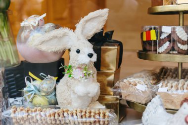 Paskalya yumurtaları, şeffaf ambalajlı Belçika waffle 'ları ve güneşli bir bahar gününde bir mağazada sergilenen çikolatalarla dekoratif Paskalya tavşanı manzarası. Paskalya Waffle konsepti, Paskalya zamanı, Paskalya