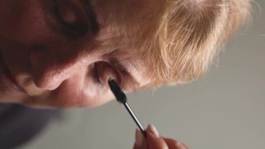 Genç bir Kafkas kozmetikçisi, gözleri kapalı yaşlı bir kadının özel bir fırçasıyla sol kaşını dikkatlice tarar. Akşamları lambanın ışığı altında bir güzellik salonunda oturur.