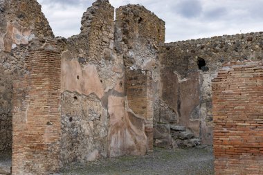 İtalya 'da bulutlu ve bulutlu bir yaz gününde, Pompeii antik şehrindeki bir yerleşim yerinin enkazının güzel manzarası..