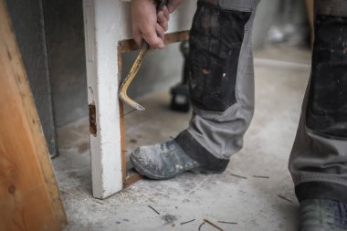 Tanımlanamayan beyaz görünümlü genç bir erkek marangoz, eski ahşap bir kapının altından çivileri çıkartıyor ve levyeyi ayağıyla tutuyor. Tamiratın yapıldığı bir odada duruyor, yakından bakıyor. Konsept