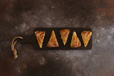 Beş yeni kesilmiş kraliyet galeti, siyah bir kesme tahtasının üzerinde, düz, orta ölçekli bir masada yatıyor. Tatil zamanı, galet yeme zamanı..