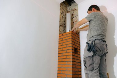 Genç yakışıklı beyaz bir adam şöminenin bacasına taze çimento harcı döşeyerek tuğlayı iki eliyle bastırıyor, gün boyunca bir odada sandalyeye basıyor, seçici bir odak ile aşağıdan yakından bakıyor. Temiz tuğla işi kavramı