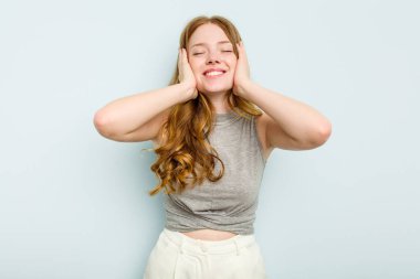 Mavi arka planda soyutlanmış beyaz bir kadın ellerini başının üstünde tutarak neşe içinde gülüyor. Mutluluk kavramı.