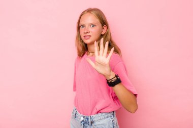 Pembe arka planda izole edilmiş beyaz bir kız, yakın bir tehlike nedeniyle şoka uğruyor.