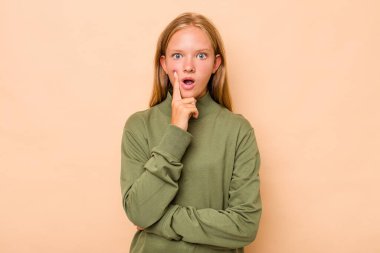 Kafkasyalı genç kız bej arka planda izole edilmiş. Harika bir fikri var, yaratıcılık kavramı..