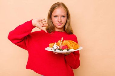 Elinde bej arka planda izole edilmiş waffle tutan beyaz bir kız hoşlanmadığı bir jesti gösteriyor. Anlaşmazlık konsepti.