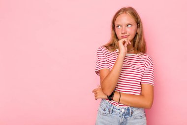 Kafkasyalı genç kız pembe arka planda izole edilmiş rahat bir şekilde fotokopi odasına bakan bir şey düşünüyor..