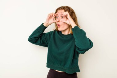 Beyaz arka planda izole genç beyaz kadın bir başarı fırsatı bulmak için gözlerini açık tutuyor..