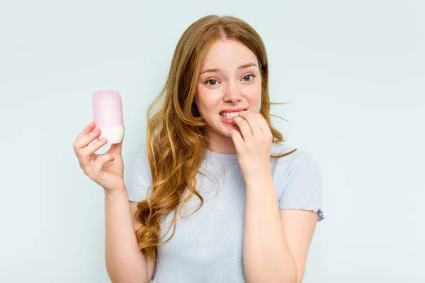 Ung Kaukasisk Kvinna Som Håller Deodorant Isolerad Blå Bakgrund Bita — Stockfoto