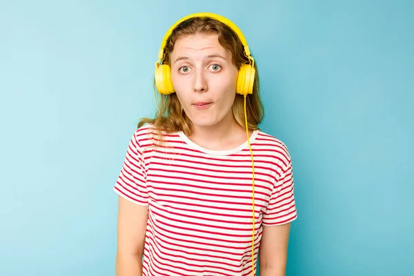 Mladá Běloška Nosí Sluchátka Izolované Modrém Pozadí Pokrčí Rameny Otevřené — Stock fotografie