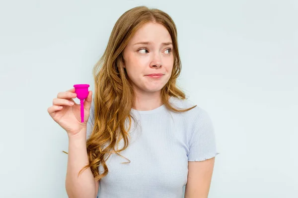 Jonge Blanke Vrouw Houdt Menstruatiecup Geïsoleerd Blauwe Achtergrond Verward Voelt — Stockfoto
