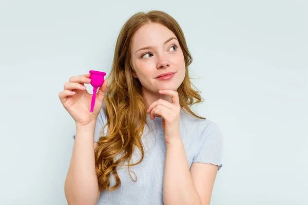 Jonge Blanke Vrouw Met Menstruatiecup Geïsoleerd Blauwe Achtergrond Kijken Zijwaarts — Stockfoto