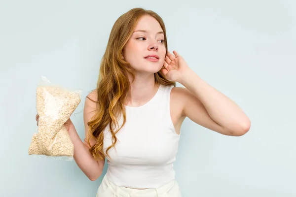 Young Caucasian Woman Holding Oatmeal Isolated Blue Background Trying Listening — Stock Photo, Image